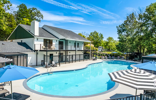 A large outdoor swimming pool with a striped sun lounger.