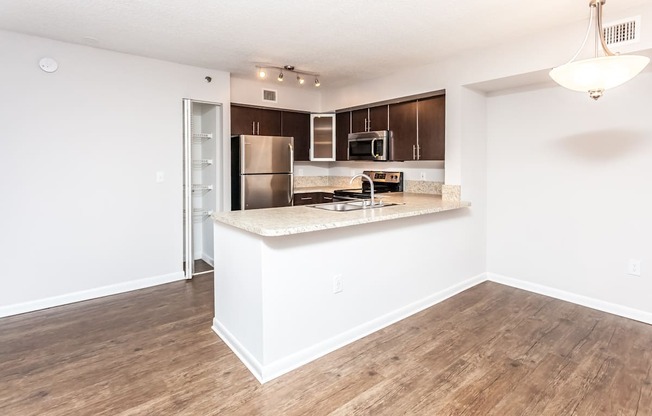 A kitchen with a refrigerator, microwave, and oven.