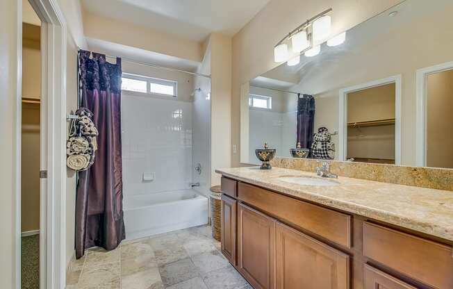 a bathroom with a shower and a sink and a mirror