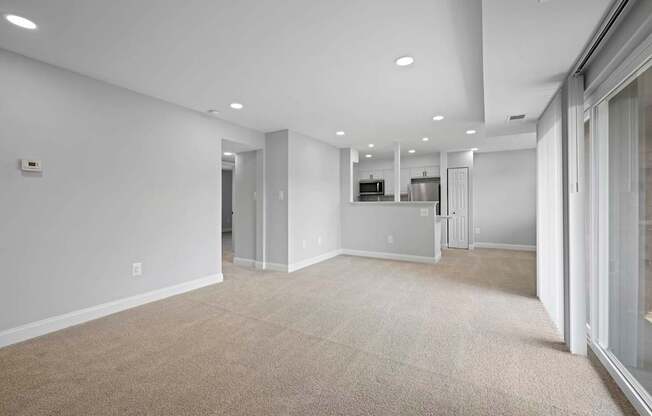 A spacious, empty room with a carpeted floor and white walls.