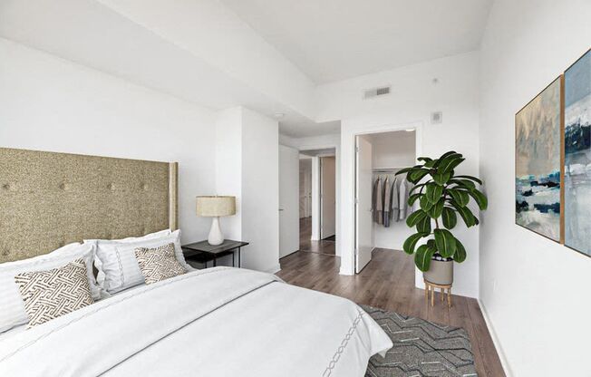 a bedroom with a bed and a potted plant
