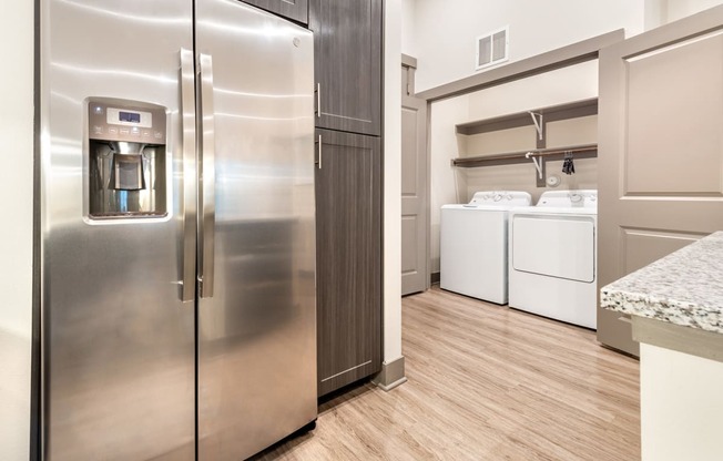 A Large Kitchen With Granite Counter Tops and Stainless Steel Appliances and a Full Size Washer and Dryer at The Bridge at McKinney, McKinney, Texas, 75069