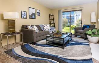 a living room with a couch coffee table and a sliding glass door Copper Ridge Apartments, Renton, 98055