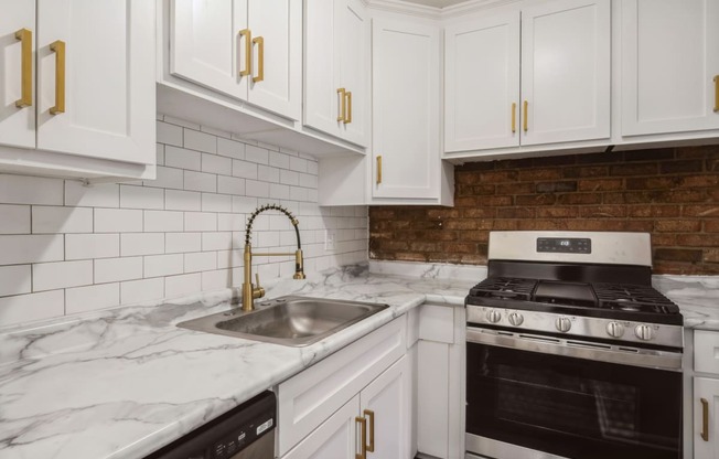 a kitchen with white cabinets and white marble countertops