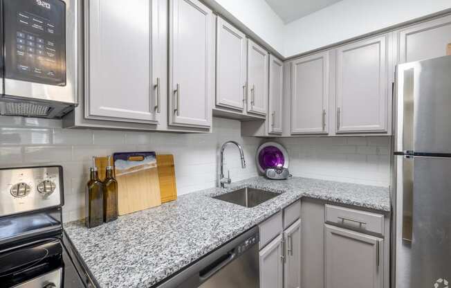 a kitchen with white cabinets and granite counter tops and a sink