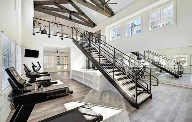 A gym with treadmills and a staircase.
