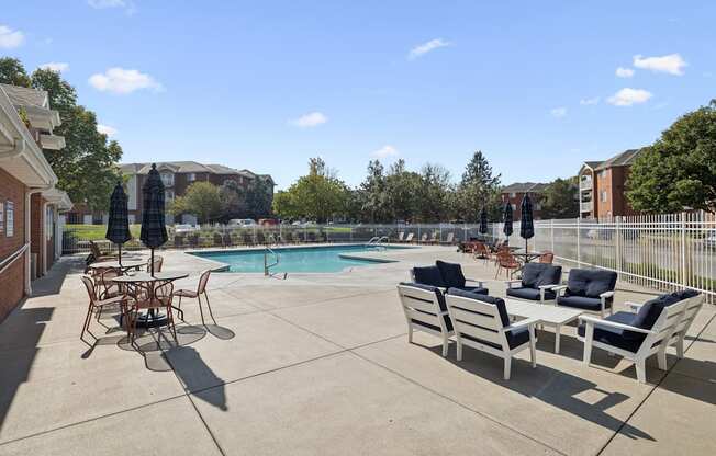 A pool area with chairs and a table.