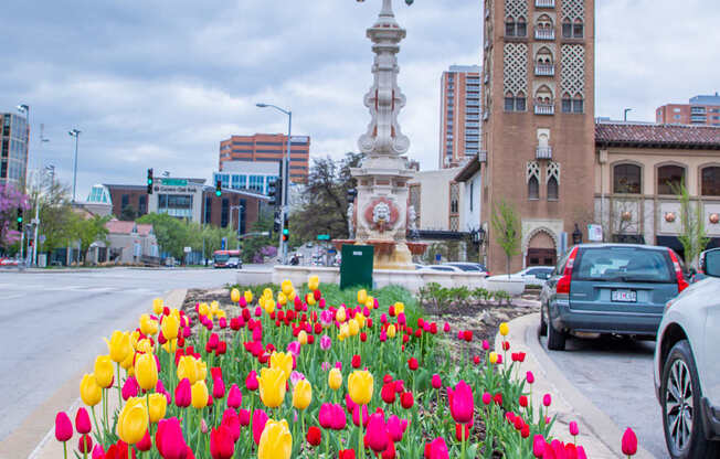 a garden of tulips in front of a clock tower