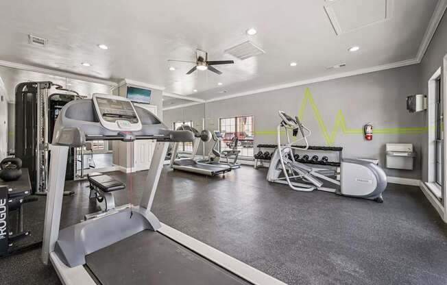 A gym with treadmills, elliptical machines, and other exercise equipment.