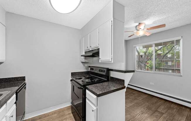 A kitchen with a black stove top oven and white cabinets.