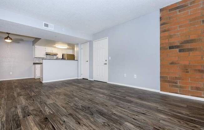 A room with wooden flooring and a brick wall.