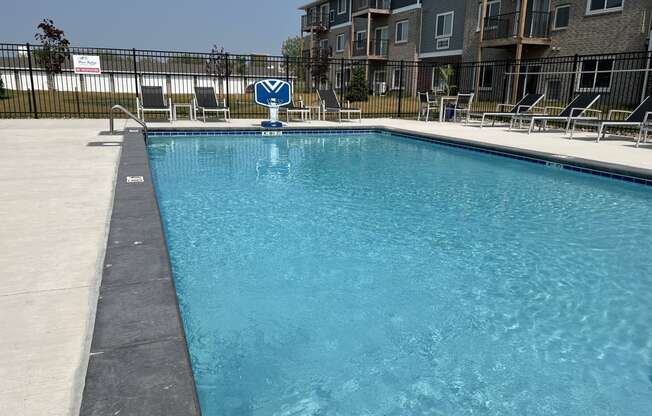 Sparkling blue pool surrounded by lounge chairs.