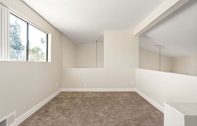 A room with a carpeted floor and a window.