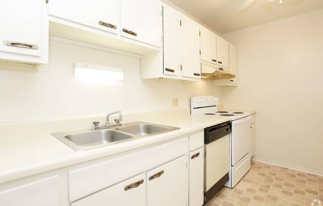 a kitchen with white cabinets and a sink and a stove