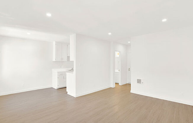 A white room with a wooden floor and a white cabinet.