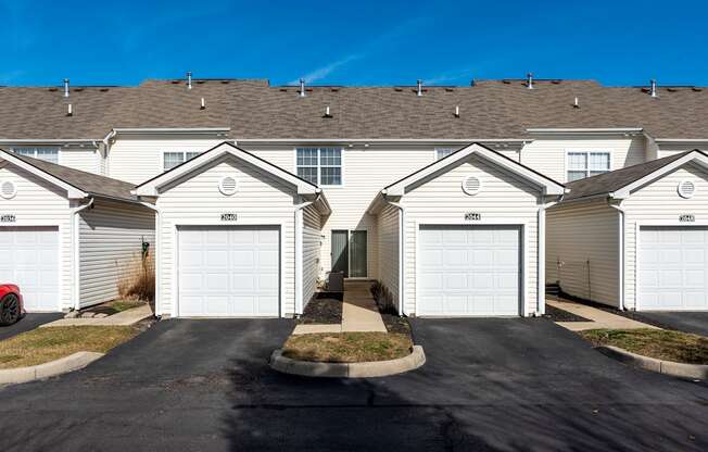 a row of houses with white roofs and garages at Traditions at Slate Ridge, Reynoldsburg
