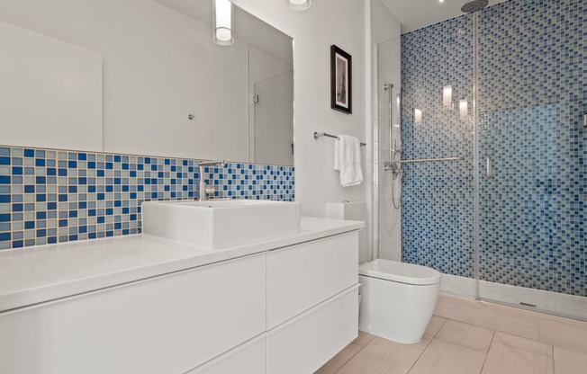 a bathroom with a blue and white tiled wall