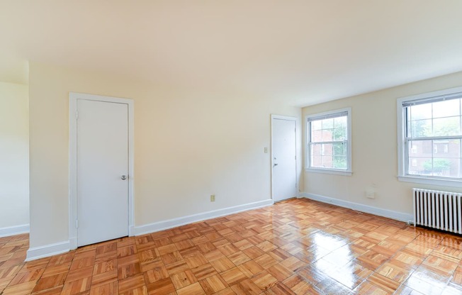 vacant living area with hardwood flooring and large windows at colonnade apartments in washington dc