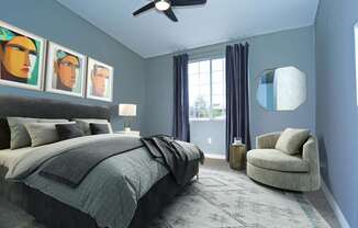 A bedroom with a bed, chair, and artwork on the wall.