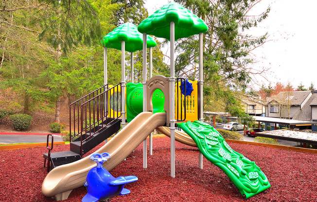 A playground with a green slide and a blue slide.