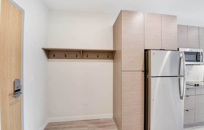 A kitchen with a refrigerator and a door.