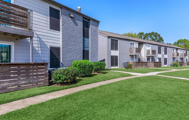 a large lawn in front of a brick building