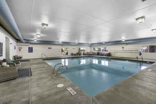 a large indoor swimming pool with a diving board  at Camelot Apartment Homes, Washington