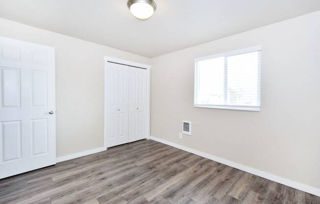 an empty living room with white walls and wood flooring