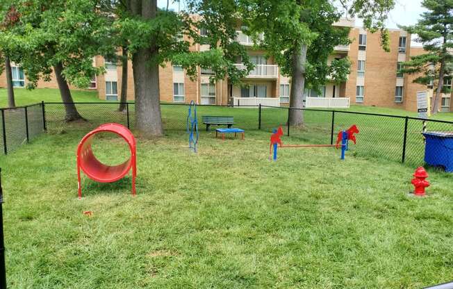 a playground in a park with trees and a fire hydrant at The Glendale Residence, Maryland, 20706