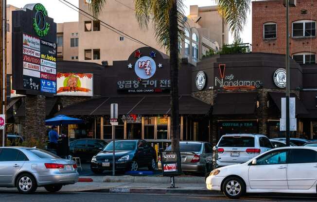 a city street with cars parked in front of a restaurant