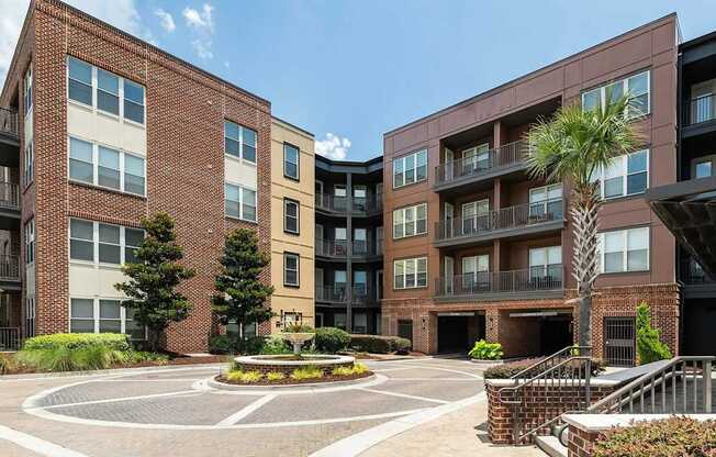 A large brick building with a courtyard in front.