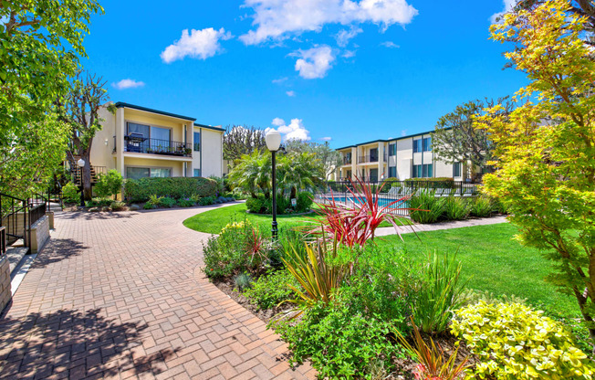 a view of a garden with a building in the background at Casa Del Amo Apartments, Torrance