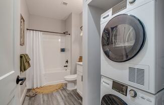 a washer and dryer in a laundry room next to a bathroom