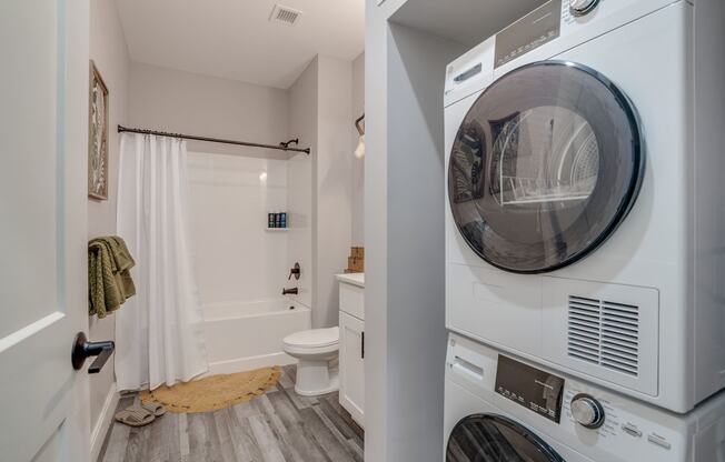 a washer and dryer in a laundry room next to a bathroom