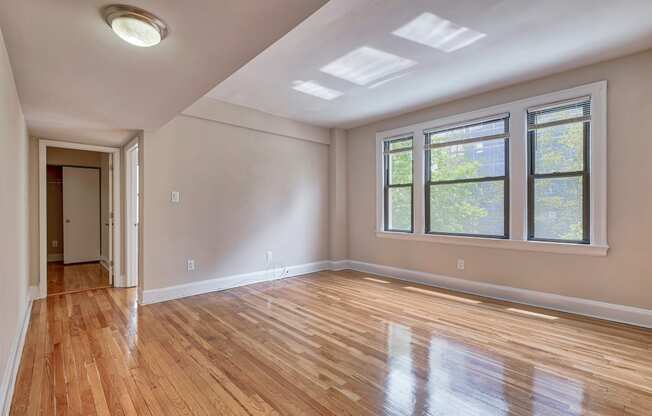 an empty living room with hardwood floors and a large window