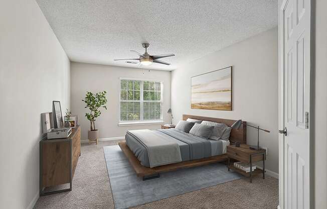 Model Bedroom with Carpet and Window View at Retreat at Stonecrest Apartments located in Lithonia, GA.