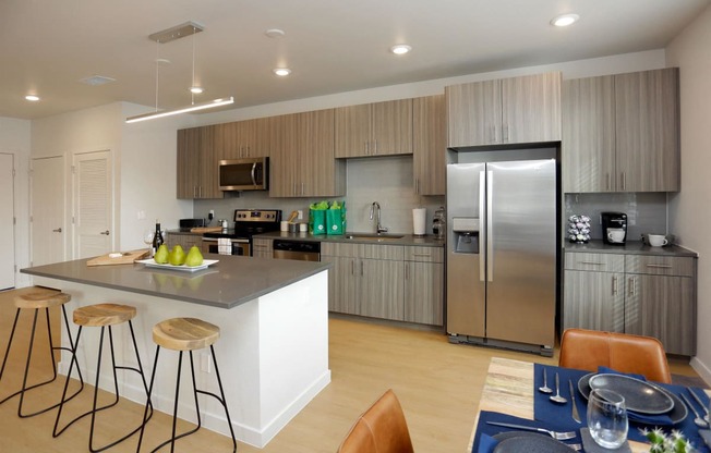 a kitchen with a large island and a stainless steel refrigerator