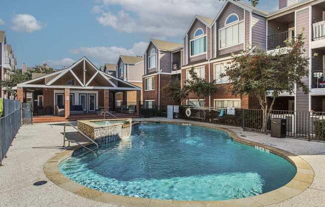 A swimming pool in a residential area surrounded by houses.