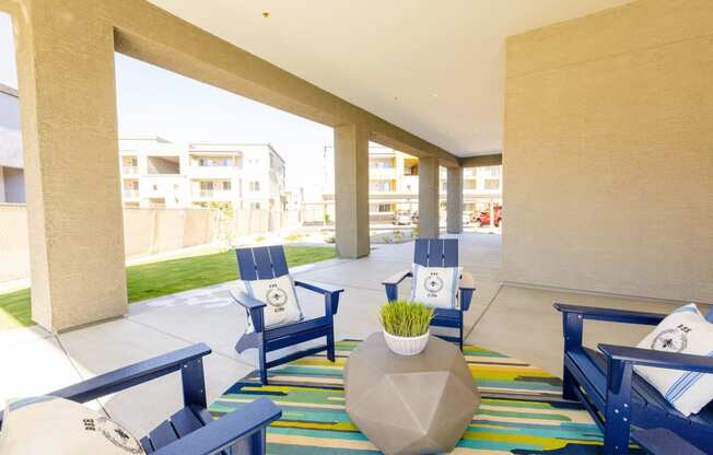 the lobby of a hotel with blue chairs and a colorful rug