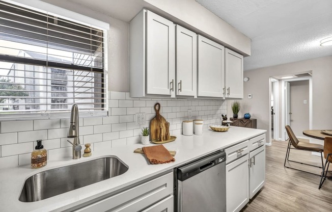 an open kitchen with white cabinets and a sink