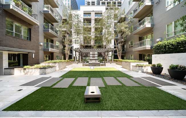 A courtyard with a bench and a tree in the middle.