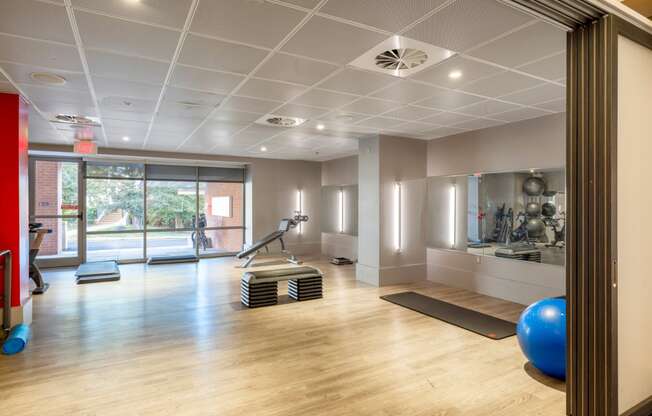 a gym with yoga mats and exercise equipment on a wooden floor
