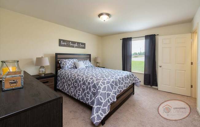A bedroom with a bed, nightstand, closet and window.