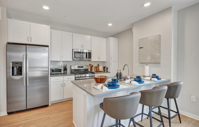 a kitchen with white cabinetry and stainless steel appliances