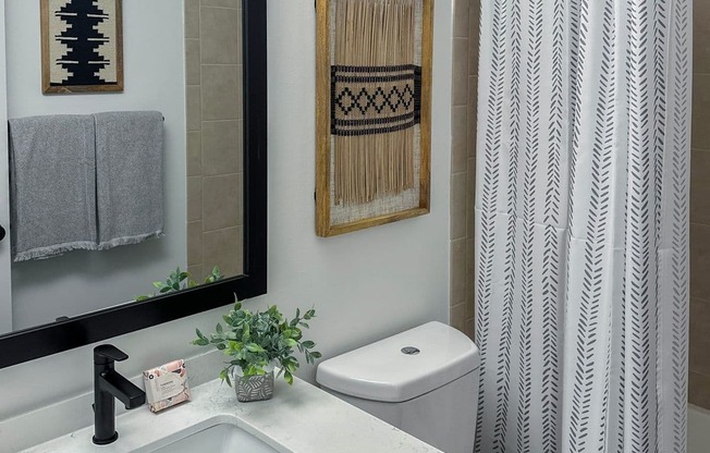 a small bathroom with a white sink and toilet and a white shower curtain