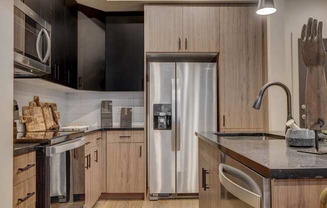 a kitchen with wooden cabinets and a stainless steel refrigerator