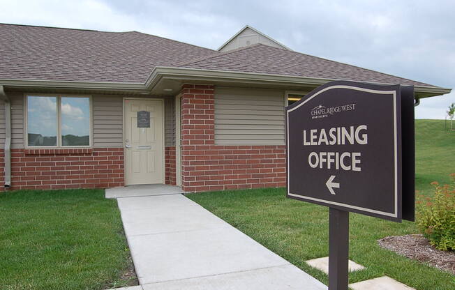 a house with a leasing office sign in front of it