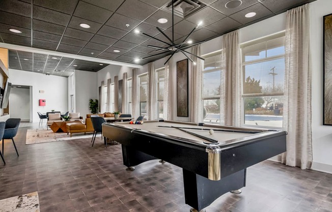 a game room with a pool table and windows at CityView, North Kansas City, Missouri