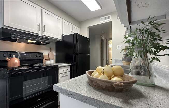 A black oven is on the left side of a black refrigerator.