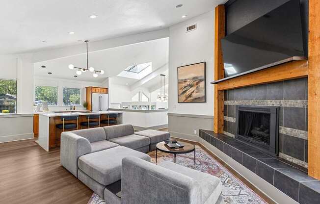 A modern living room with a grey sofa and a fireplace.